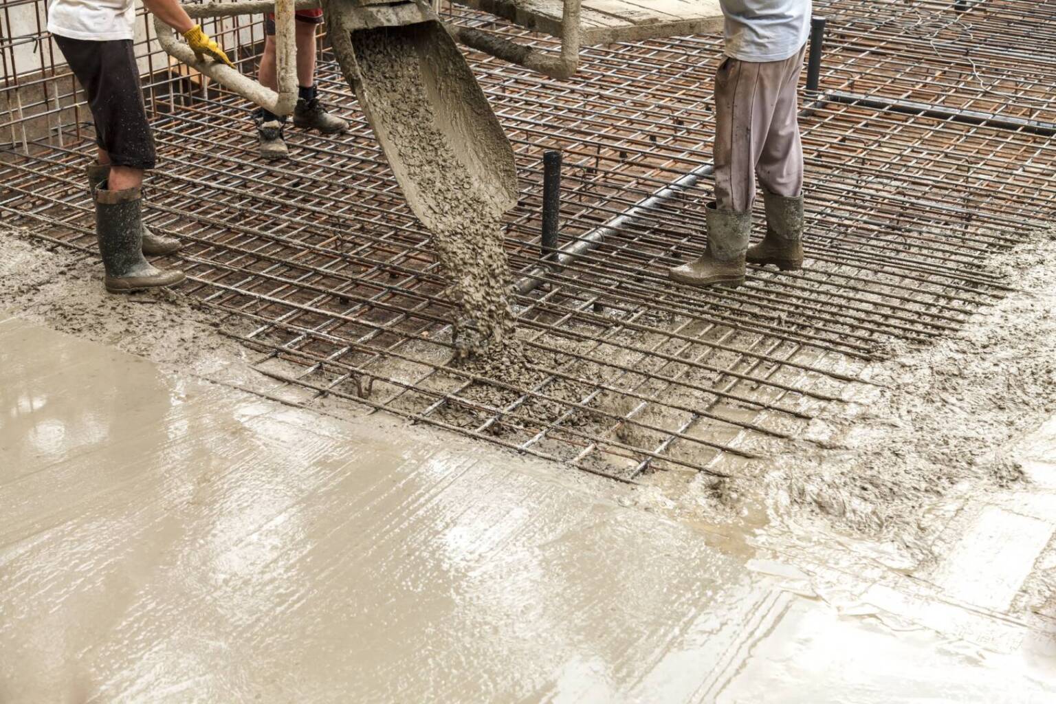 Pouring concrete into the construction of the house. Builders are pouring ready-mixed concrete